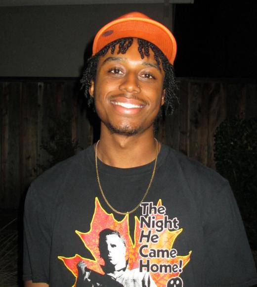 Man wearing a graphic t-shirt with an orange colored hat